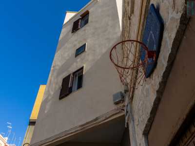 Alla parete � appeso un canestro da basket che pare inutilizzato da tempo